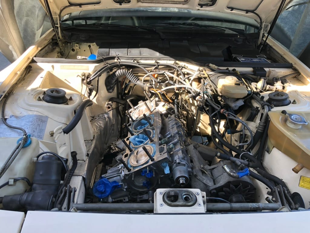 The white 944 engine bay coming back together with new seals and hoses
