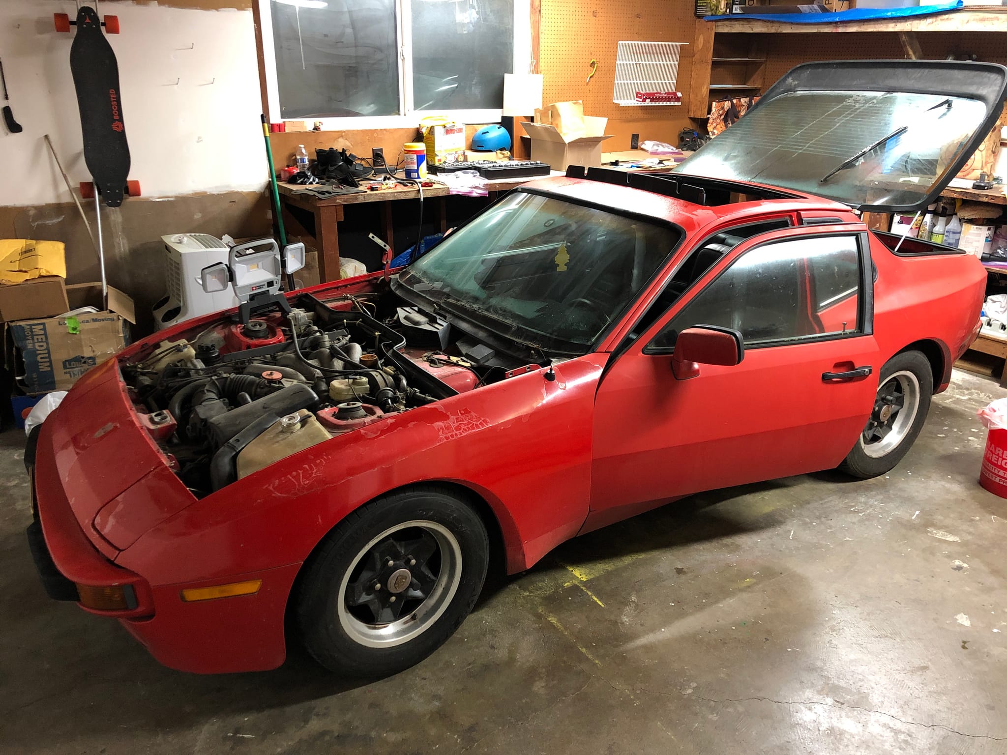 The red Porsche 944 in the garage with its hood open