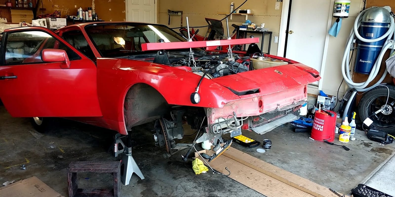 The red car up on stands with the engine out