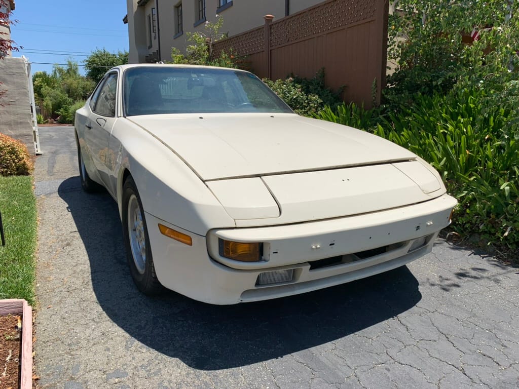 The white 1986 Porsche 944 parked in a driveway
